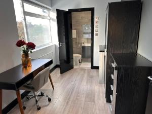 a room with a desk and a bathroom with a toilet at Letzi Private En-Suite In Harrow in Pinner