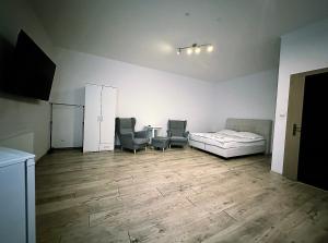a room with a bed and two chairs in it at Apartamenty Retro in Dąbrowa Górnicza