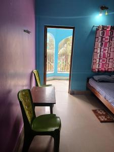 a room with a chair and a bed and a mirror at HOTEL NAKSHATRA in Digha