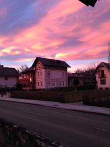 une maison sur le côté d'une route avec un coucher de soleil dans l'établissement Vila Alice Bled - Adults only, à Bled