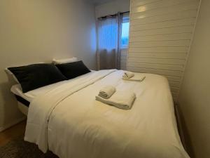 a bedroom with a white bed with towels on it at Enter Backpack Apartments in Tromsø