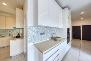 a kitchen with white cabinets and a sink at Rush Reliance Mt. Lavinia in Attidiya