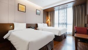um quarto de hotel com duas camas e uma janela em Gloucester Hotel Jeonju em Jeonju