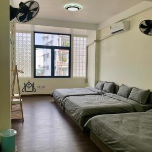1 dormitorio con 2 camas y ventana en DeMi Homestay 2 - Châu Đốc en Ấp Vĩnh Ðông