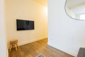 uma sala de estar com televisão na parede em Stylish 50m² Two-Bedroom Apartment (SD-23-K) em Eindhoven