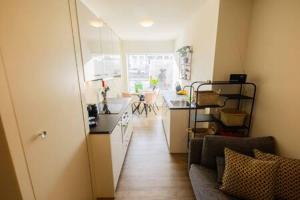 a room with a kitchen and a living room with a couch at Stylish 50m² Two-Bedroom Apartment (SD-23-K) in Eindhoven