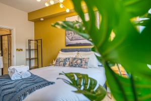 Un dormitorio con una cama con toallas y una planta en Haworth Heights - An AMAZING Aparthotel!, en Haworth