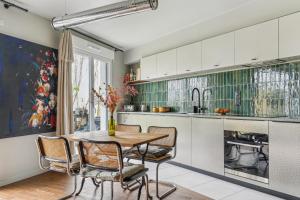 cocina con mesa de madera y sillas en Maison duplex avec jardin, en Saint-Ouen