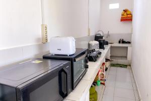 a kitchen with a stove with a toaster at Kana Guest House Mitra RedDoorz in Uluwatu