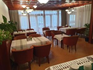 a dining room with tables and chairs and windows at Pribina Penzión in Nitra