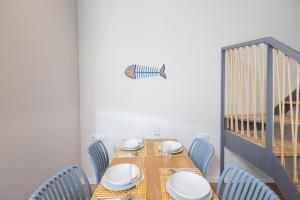 a dining room with a table and blue chairs at FLORIT FLATS - The Seagull Apartments in Valencia
