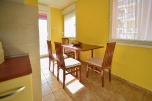 a dining room with a wooden table and chairs at Apartman Odzaci in Odžaci