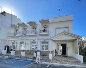 un edificio bianco senza un cartello di parcheggio davanti di Hotel Anthousa a Samos