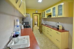 a kitchen with yellow cabinets and a counter top at Apartman Odzaci in Odžaci