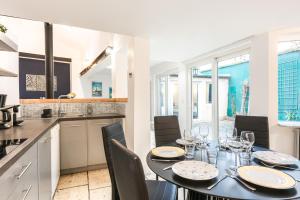 cocina y comedor con mesa y sillas en Garden Loft in the heart of Paris - 6 guests en París