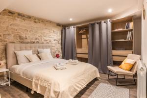 1 dormitorio con cama y pared de ladrillo en Garden Loft in the heart of Paris - 6 guests en París