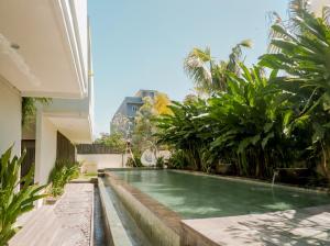 a swimming pool in the backyard of a house at D'Green Kuta Managed by ARM Hospitality in Legian