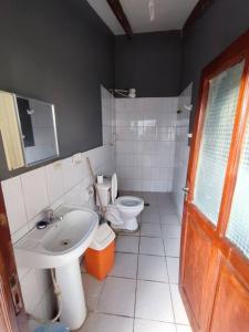 baño con lavabo, aseo y puerta en Acogedora, independiente y tradicional Casa - Karapanza, en Sucre