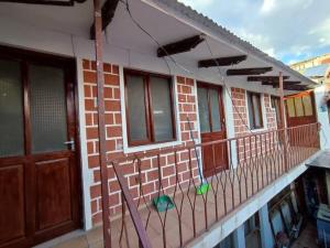 uma varanda de uma casa com portas e uma cerca em Acogedora, independiente y tradicional Casa - Karapanza em Sucre