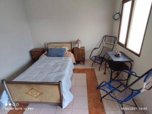 1 dormitorio con 1 cama, mesa y sillas en Acogedora, independiente y tradicional Casa - Karapanza, en Sucre