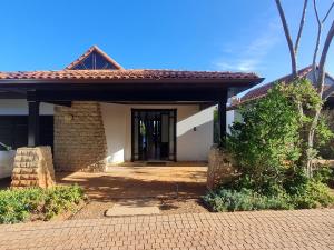 una casa con una puerta y un edificio de ladrillo en Zimbali - Luxury 4 Bedroom KRH1, en Ballito