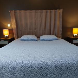a bedroom with a bed with two pillows on it at Villa piscine proche plages in Angresse