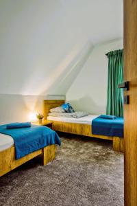 um quarto com 2 camas e lençóis azuis em Domki Magia Gór-nocleg obok Term em Szaflary