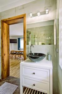 uma casa de banho com um lavatório num balcão com um espelho em Domki Magia Gór-nocleg obok Term em Szaflary