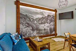 uma sala de estar com uma grande imagem de uma montanha em Domki Magia Gór-nocleg obok Term em Szaflary