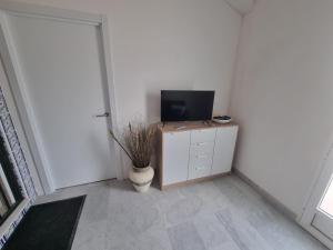 a room with a television on a dresser with a cabinet at Taylors Camposol Apartment in Mazarrón