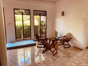 un soggiorno con sedie, tavolo e finestre di Dream Villa a Matara