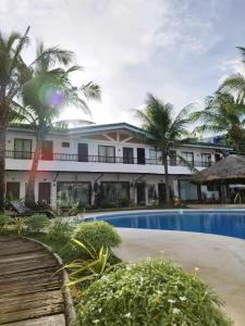 a resort with a swimming pool and palm trees at Casa Marta Hotel in Iloilo City