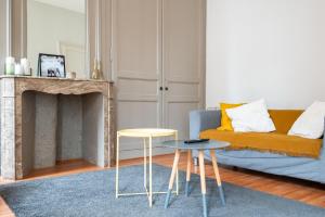 salon z kanapą i dwoma stołami w obiekcie Charmant appartement central w Lille