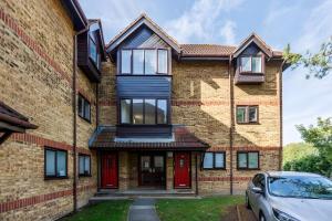 a house with red doors and a car parked in front at Camberwell Elegance 3BR Luxury Flat in London