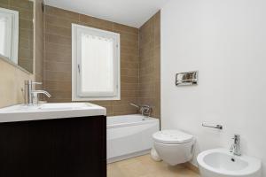 a bathroom with a sink and a toilet and a tub at Villa Marconi Apartment 6 in Golfo Aranci +19 photos