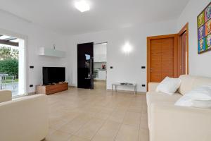 a living room with a couch and a television at Villa Marconi Apartment 6 in Golfo Aranci