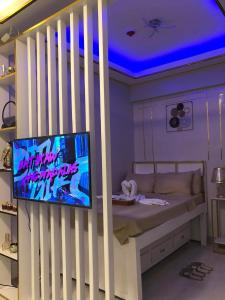 a room with a bed and a tv on a wall at KenZel Staycation in Manila
