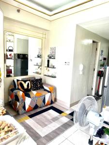 a bedroom with a bed and a fan in it at KenZel Staycation in Manila