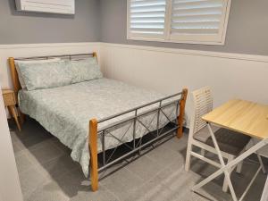 Ce lit se trouve dans un dortoir doté d'une table et d'une table. dans l'établissement Bedroom with Ensuite - Amazing Strand Location, à Townsville