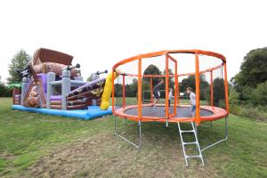 een jongen die op een trampoline speelt in een speeltuin bij Mobil Home XXL 4 chambres - Camping Le Clos Cacheleux in Miannay