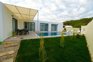 a house with a backyard with a swimming pool at Villa Mila Fethiye in Fethiye