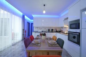 a kitchen with a wooden table with chairs around it at Villa Mila Fethiye in Fethiye