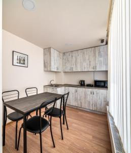 a kitchen and dining room with a table and chairs at New Tiflis Apartment Mziuri in Tbilisi City