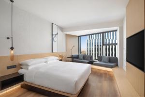a bedroom with a white bed and a large window at Fairfield by Marriott Shanghai Lingang Special Area in Shanghai