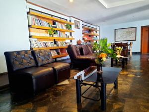 una sala de estar con 2 sofás de cuero y una mesa. en Siam Boutique Hotel โรงแรมสยามบูทีค, en Buriram