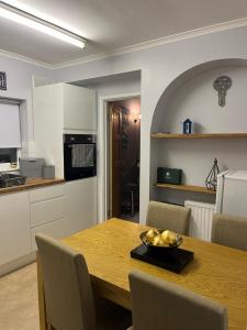 a kitchen and a table with a bowl of fruit on it at Palmbeach Place in Kent