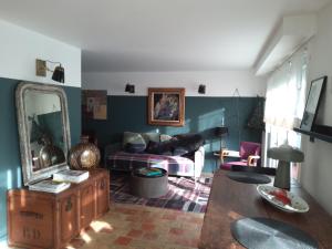 ein Wohnzimmer mit einem Sofa und einem Spiegel in der Unterkunft Après la pluie .... in Équemauville