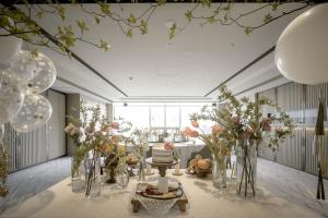 ein Zimmer mit Blumenvasen und einem Tisch mit Kuchen in der Unterkunft Daegu Marriott Hotel in Daegu