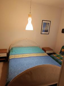 - une chambre avec un lit et un éclairage dans l'établissement Casa Diana, à Bibione