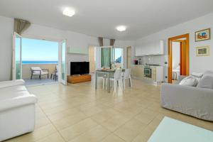 a living room with a couch and a table and a kitchen at Villa Marconi Apartment 9 in Golfo Aranci